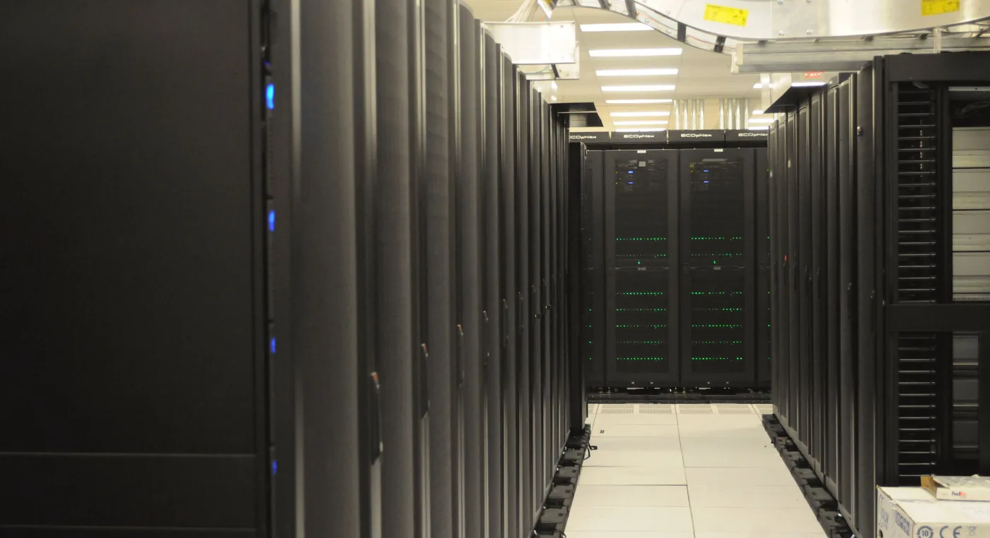 An aisle of server racks in a data center